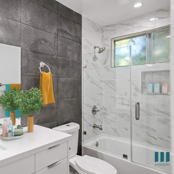 bathroom with shower bath with glass door, and vanity cabinet storage