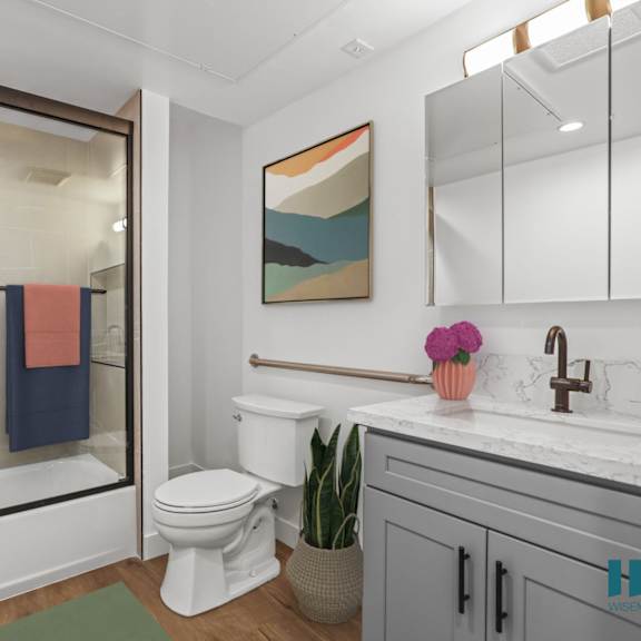 bathroom with shower-bath with a glass door and vanity cabinet storage