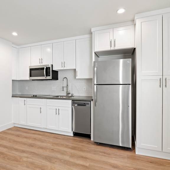 studio apartment kitchen including dishwasher, full-size refrigerator, and microwave oven