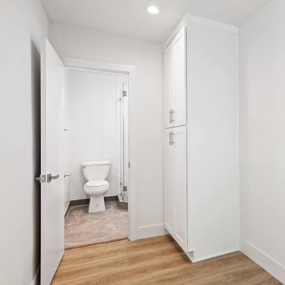 studio apartment bedroom with storage cabinet and full-size bathroom