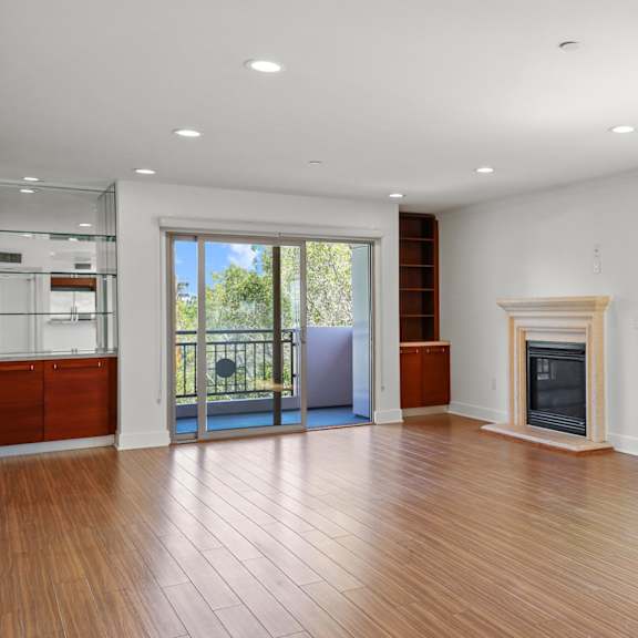 living room with built-in shelving, patio, and fireplace