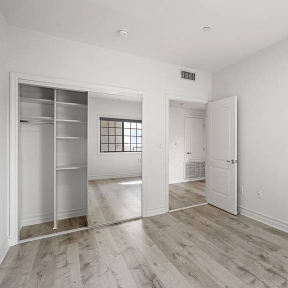 bedroom with closet with a built-in organization system and vinyl flooring
