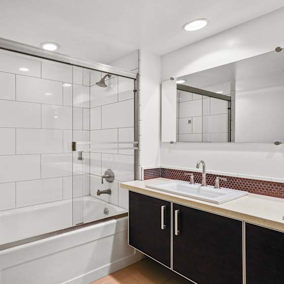 bathroom with full-size bathtub and glass doors