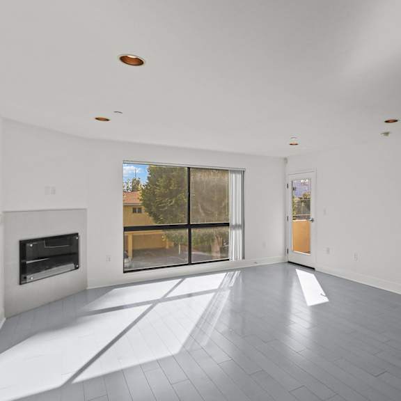 bright & spacious living room area with recessed lighting and vinyl flooring