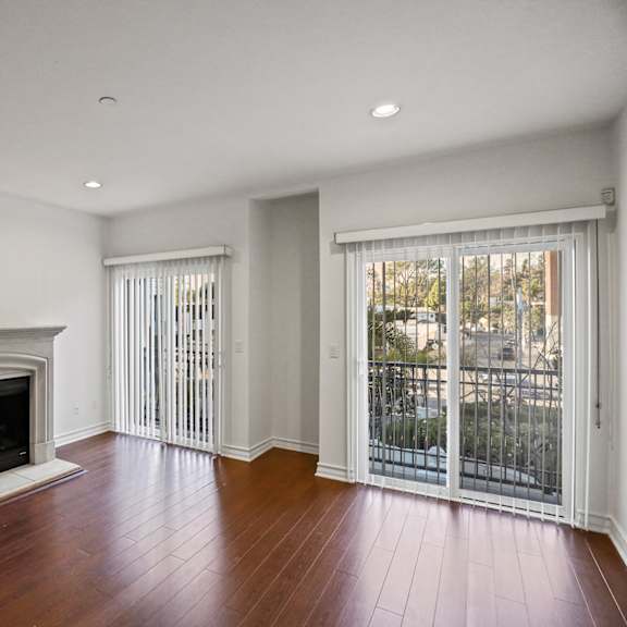 living room area with an electric fireplace,  vinyl flooring, and balcony