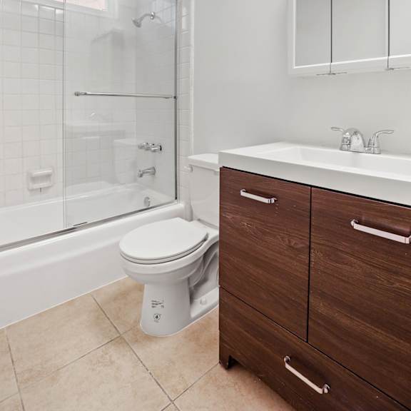 bathroom with bathtub and vanity with cabinet and drawers