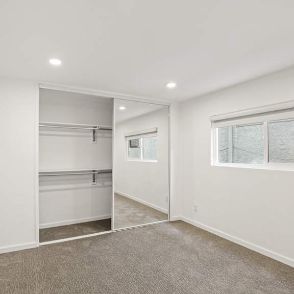 bedroom with mirrored closet, recessed lighting, and large window