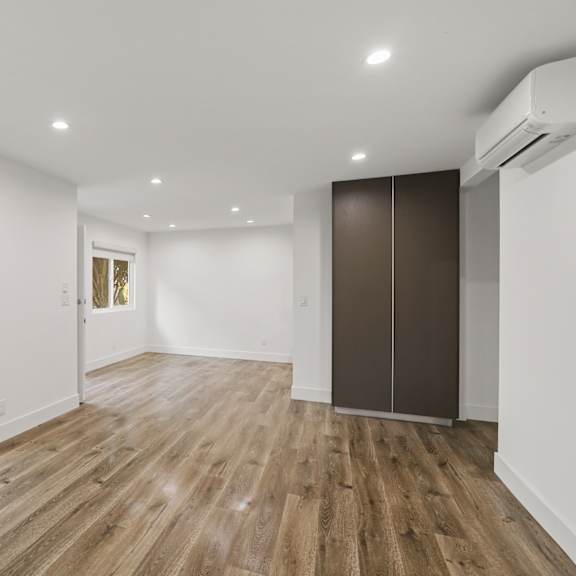 living room area with vinyl flooring, wall heater, and sliding glass door to access patio