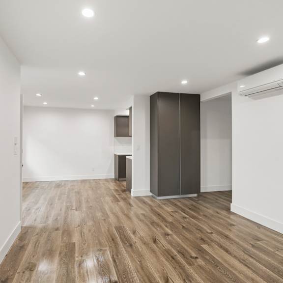 living room area with vinyl flooring, wall heater, and patio entrance