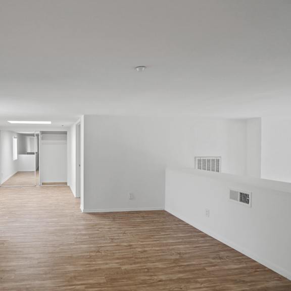 spacious loft with vinyl flooring, mirrored closet, and patio