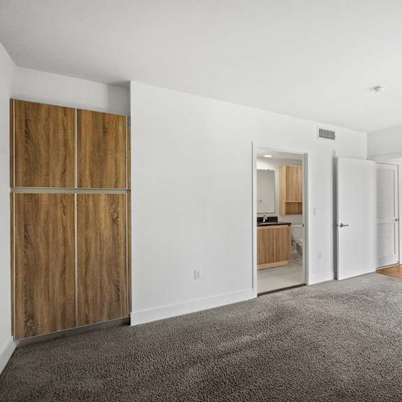 large bedroom with mirrored closet with additional built-in cabinet storage