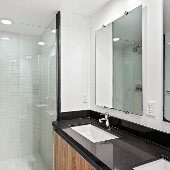 bathroom with double sinks and full-size walk-in shower