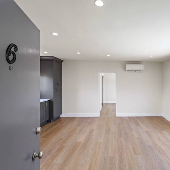 front entrance leading to living room with large-size window, recessed lighting, and vinyl flooring