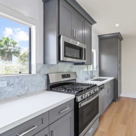 kitchen with natural window light, extra cabinet storage, and stainless steel appliances