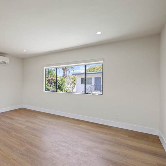 living room space with large-size windows, recessed lighting, and vinyl flooring