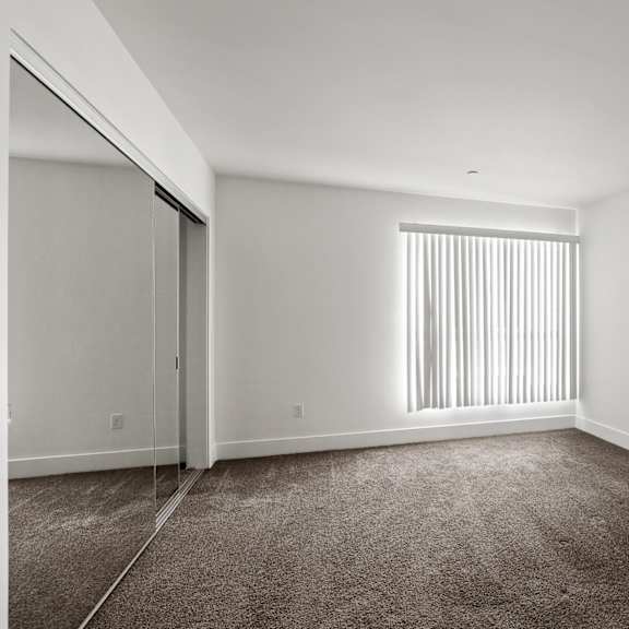 bedroom with large window and double-door closet