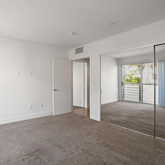 bedroom with mirrored closet and patio access