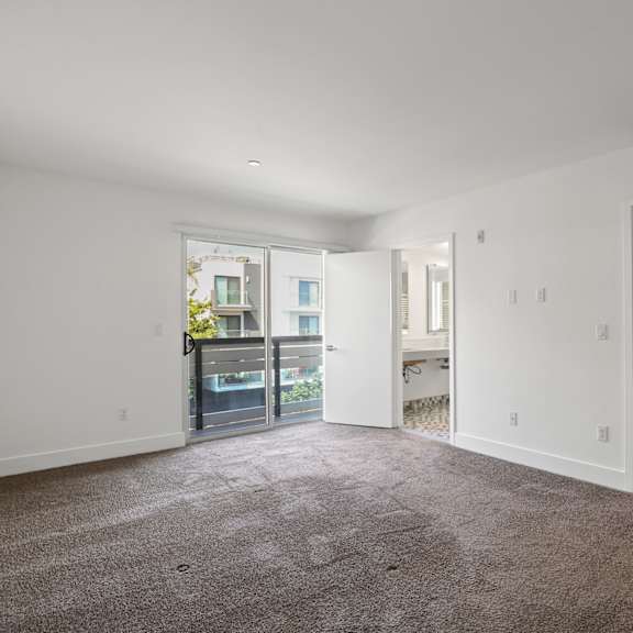 bedroom with walk-in closet and balcony