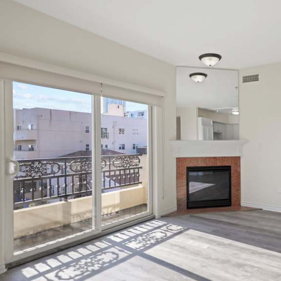 bright living room space with an electric fireplace and private balcony