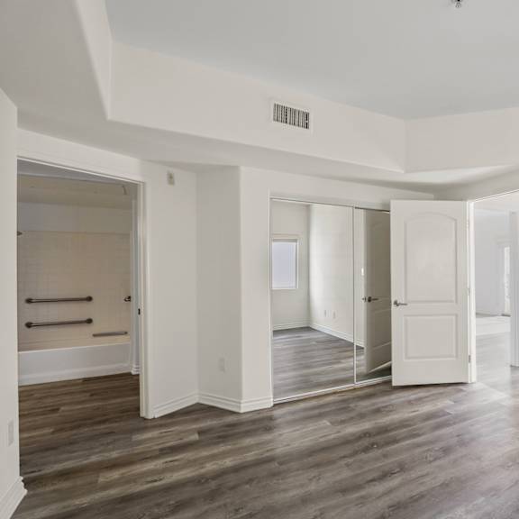 large-size bedroom with bathroom, closet, and vinyl flooring