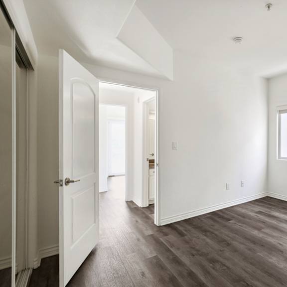 bedroom with closet, window, and vinyl flooring
