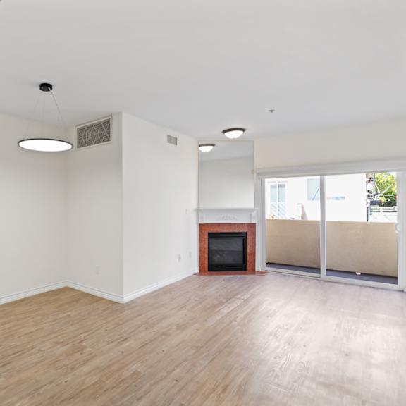 open-concept dining and living room with electric fireplace and private balcony