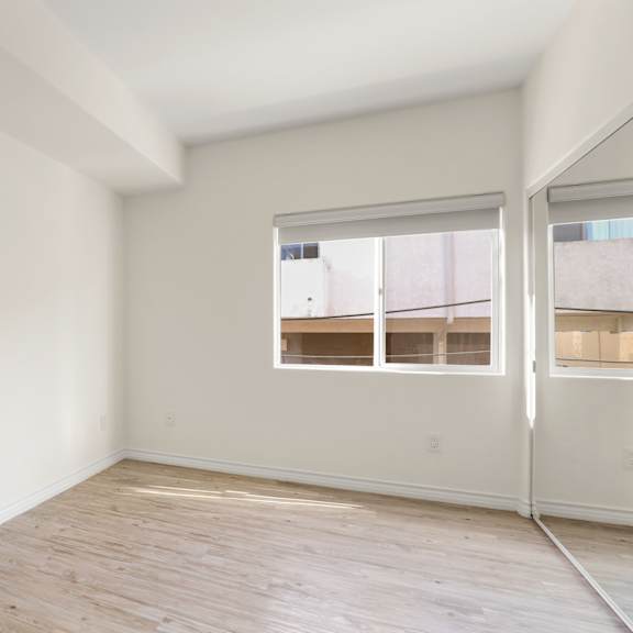 bedroom with mirrored closet and window