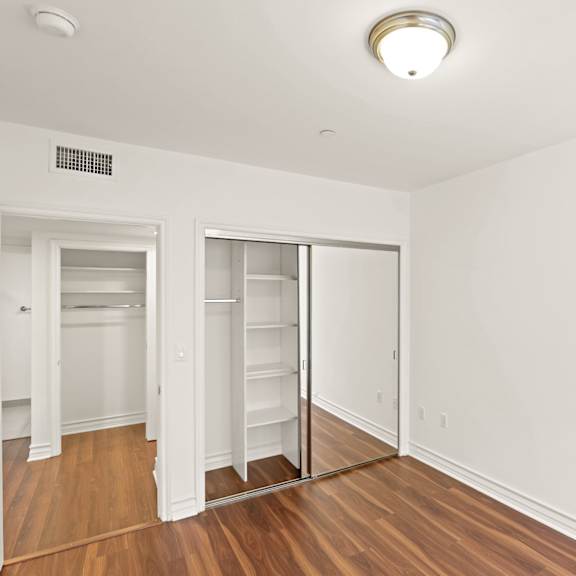 bedroom with mirrored closet and hardwood flooring