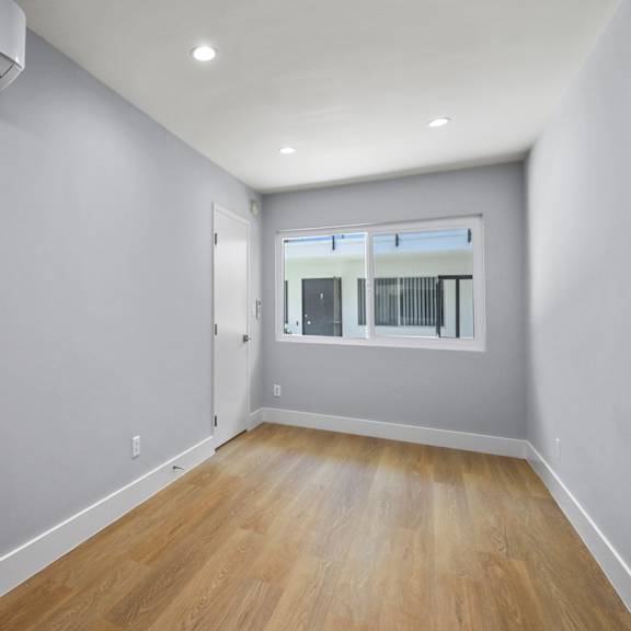 bedroom with large windows, vinyl flooring, and recessed lighting