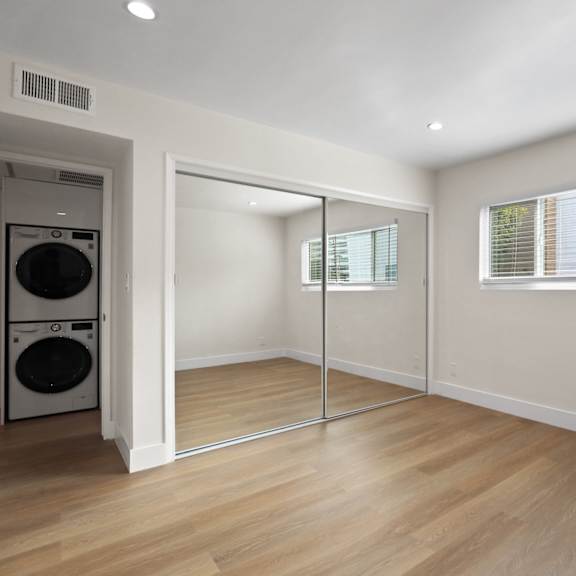 bedroom with large mirrored closet and window