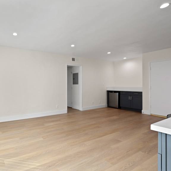 open-concept kitchen, dining and living room area with vinyl flooring