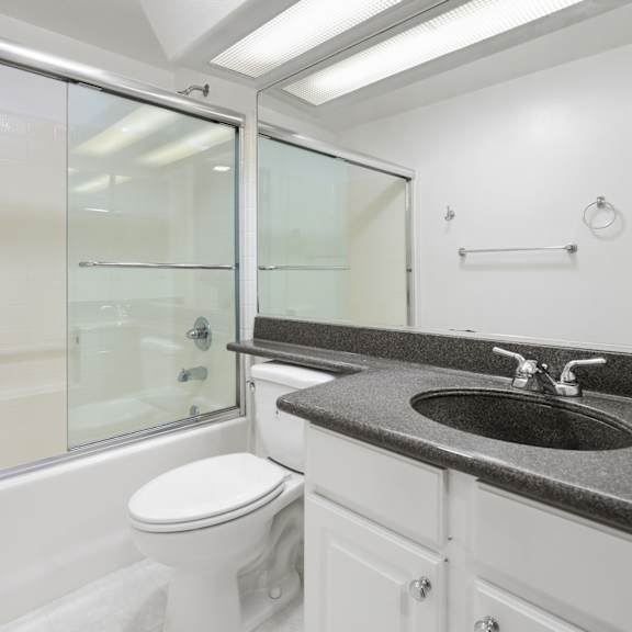 bathroom with bathtub with glass doors