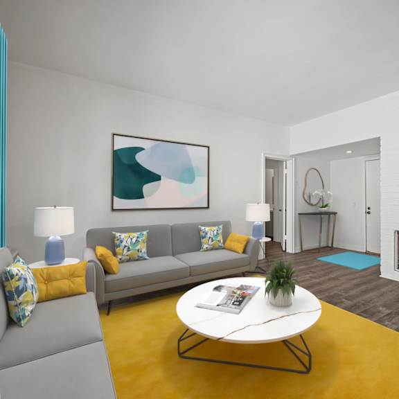 a living room with a grey couch, a white coffee table, and a yellow rug.