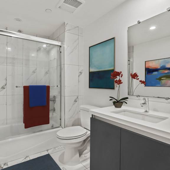 bathroom with shower bath with glass door and vanity cabinet storage