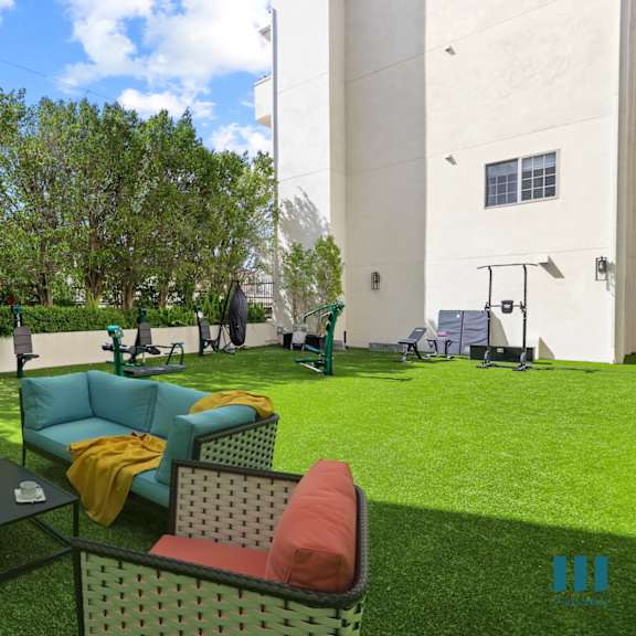 a lounge area with couches and chairs on the grass
