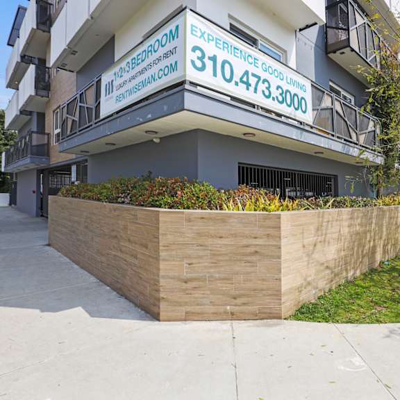a building with a sign that says "experience good living" and a phone number.