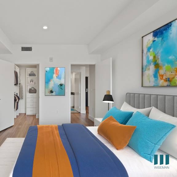 a modern bedroom with a large bed and a painting on the wall.