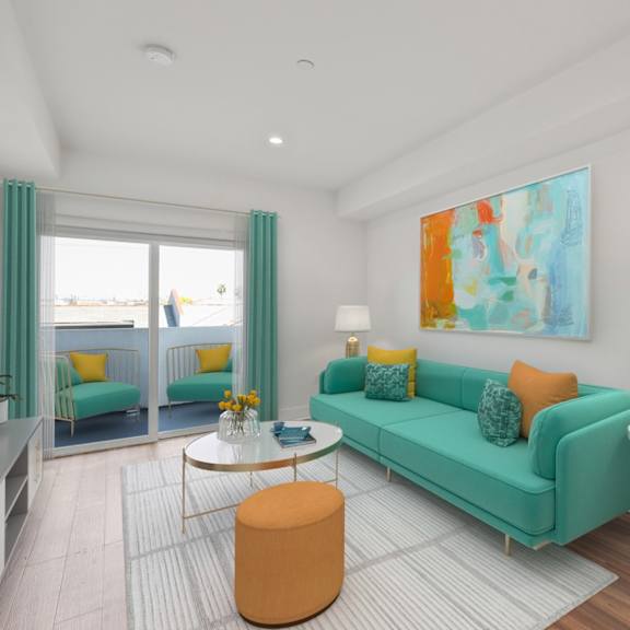 a living room with a green couch and a painting on the wall.