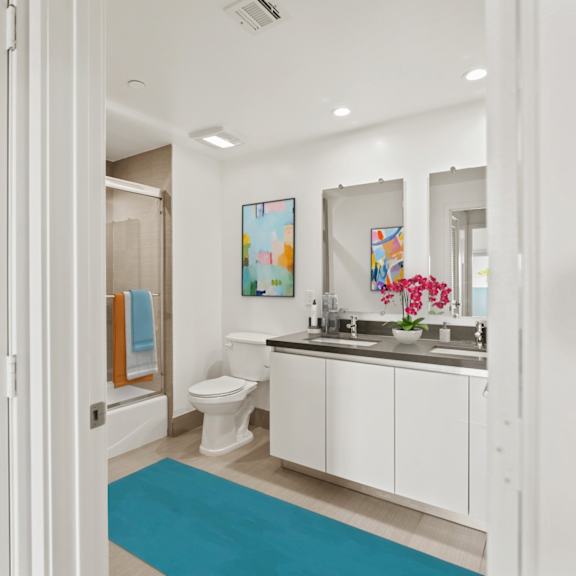 a bathroom with a toilet, sink, and mirror.