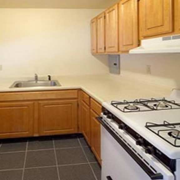 a kitchen with a stove refrigerator and sink