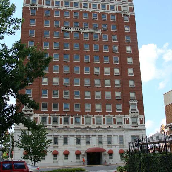 a tall red brick building with a white trim around the windows and roofline.
