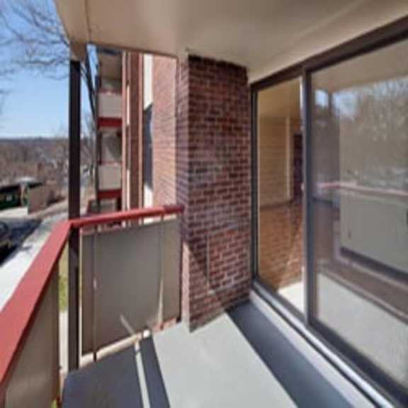 a balcony with a large window and a brick building