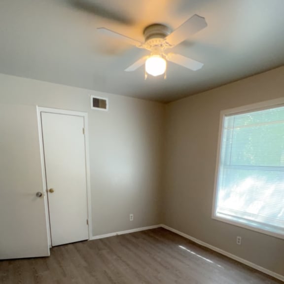 a bedroom with a ceiling fan and wood floors