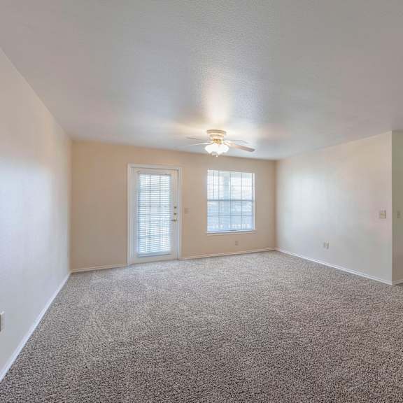 a spacious room with a carpeted floor and a bar area.