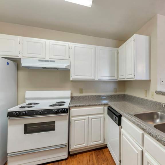 a kitchen with white cabinets and a stove top oven.
