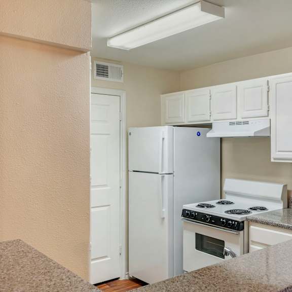 a kitchen with white appliances and cabinets.