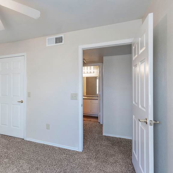 a room with a ceiling fan and two doors.