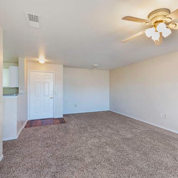 a room with a ceiling fan and carpeted floor.