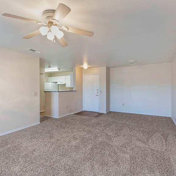 a room with a ceiling fan and carpeted floor.