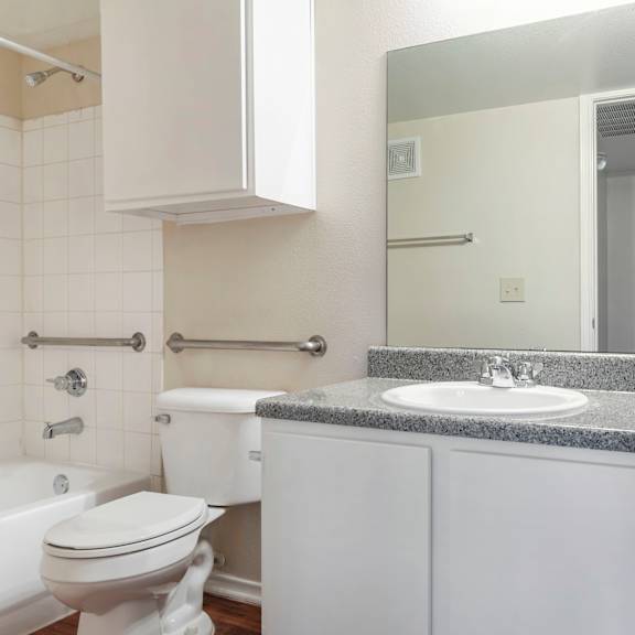 a white bathroom with a tub, toilet, and sink.